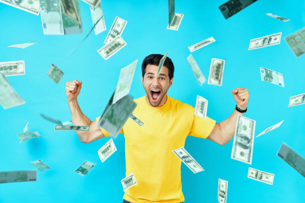 Happy excited man standing under money rain banknotes falling down Happy excited man standing under money rain banknotes falling down. Success, business, and fortune concept money rain stock pictures, royalty-free photos & images