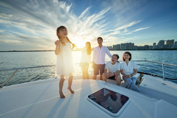 Happy family aboard a yacht out to sea stock photo