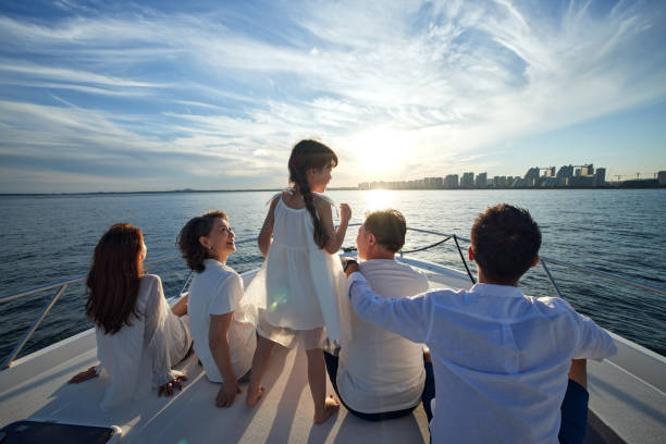 Happy family aboard a yacht out to sea stock photo