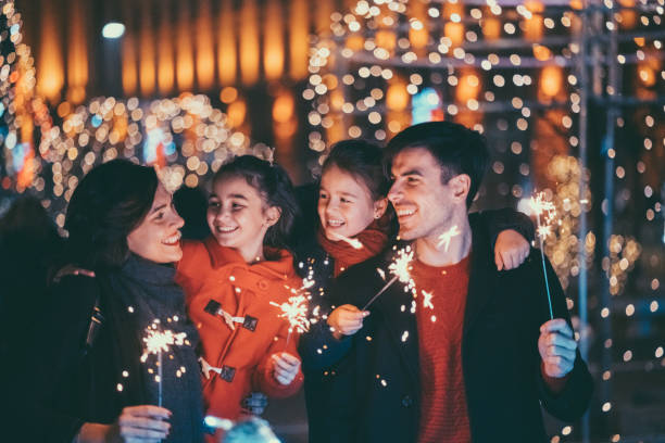 Happy family celebrating Christmas and New Year together Young family with two kids celebrating New Year new years eve girl stock pictures, royalty-free photos & images