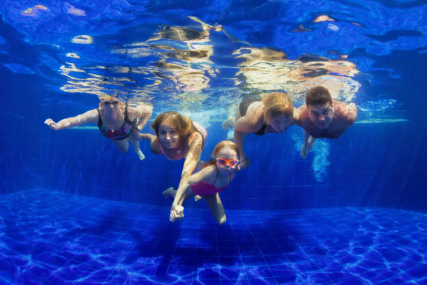 Happy family dive in swimming pool Happy family in swimming pool. Smiling mother, children and grandparents swim, dive in pool with fun - jump deep down underwater. Healthy lifestyle, people water sport activity on holidays with kids cross section photos stock pictures, royalty-free photos & images