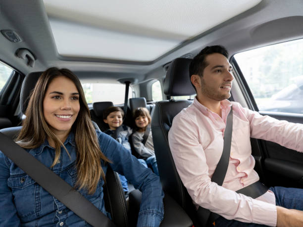 Happy family going for a ride in the car Happy Latin American family going for a ride in the car and smiling while wearing their seatbelts seat belt stock pictures, royalty-free photos & images