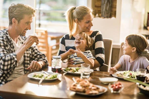 lycklig familj ha kul när du pratar under lunchtid på matbord. - family dinner bildbanksfoton och bilder