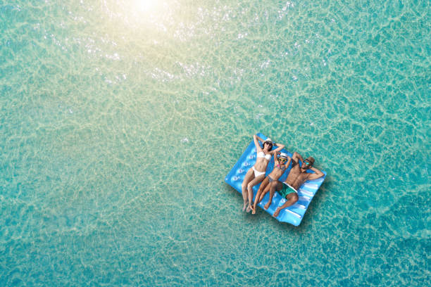 Happy family on inflatable bed on the sea