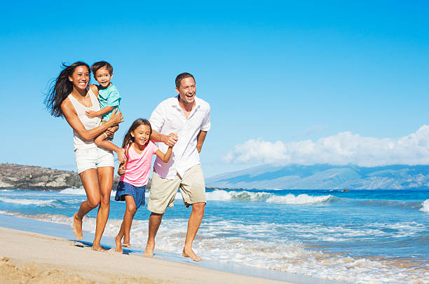 Happy Family on the Beach Happy Mixed Race Family of Four on the Beach beach holiday stock pictures, royalty-free photos & images