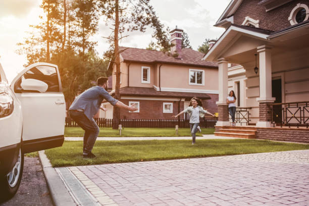 Happy family outdoors Happy family. Dad came home, daughter is running to meet him while wife is waiting on the house's porch. car lifestyle stock pictures, royalty-free photos & images