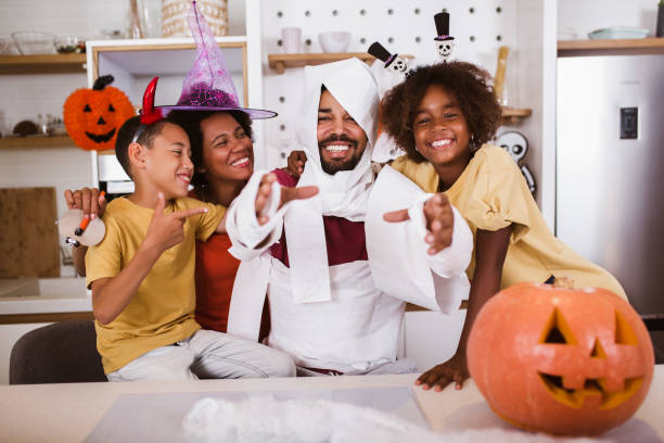 Happy family preparing for Halloween, having fun. stock photo