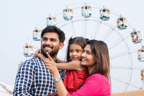 Happy family standing in front of ferris wheel