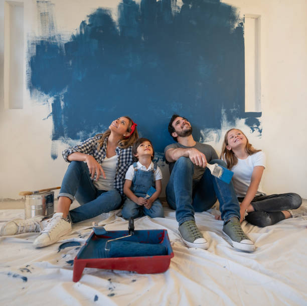 keluarga bahagia beristirahat sejenak dari melukis rumah mereka - apartemen tempat tinggal potret stok, foto, & gambar bebas royalti