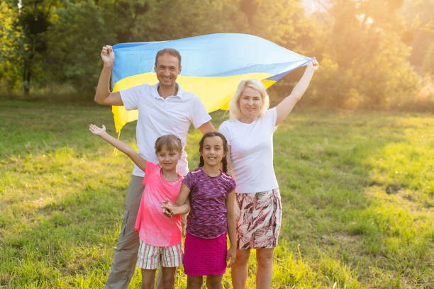 happy family with flag of ukraine in field. lifestyle stock photo