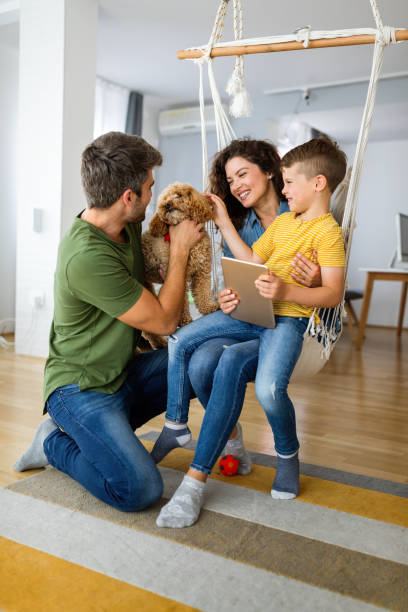 Happy family with modern devices and dog having fun, playing at home stock photo