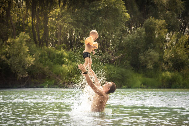 lycklig far spela son kid simning livsstil porträtt konceptet happy faderskap och barndom under sommarlovet landsbygden - bad catch bildbanksfoton och bilder