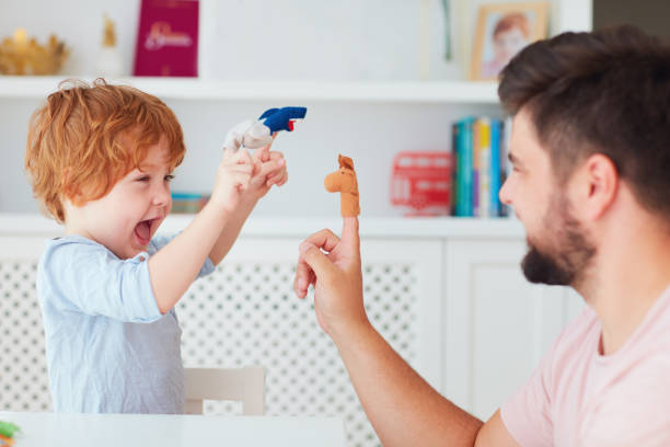 happy father playing with kid at home, funny puppet games, animal impersonated stock photo