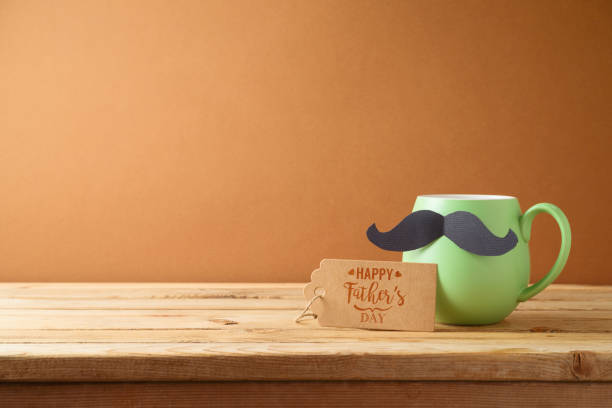 Happy Fathers day concept with green coffee cup, mustache and gift tag on wooden table Happy Fathers day concept with green coffee cup, mustache and gift tag on wooden table fathers day stock pictures, royalty-free photos & images