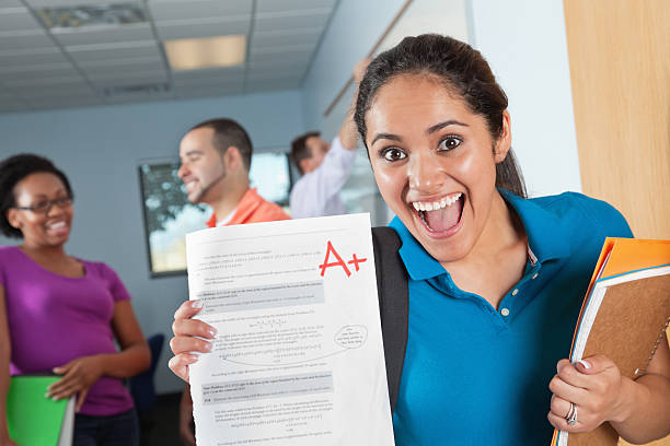 Happy Female Student in Class With Great Test Grade Happy Female Student in Class With Great Test Grade. students exam results stock pictures, royalty-free photos & images