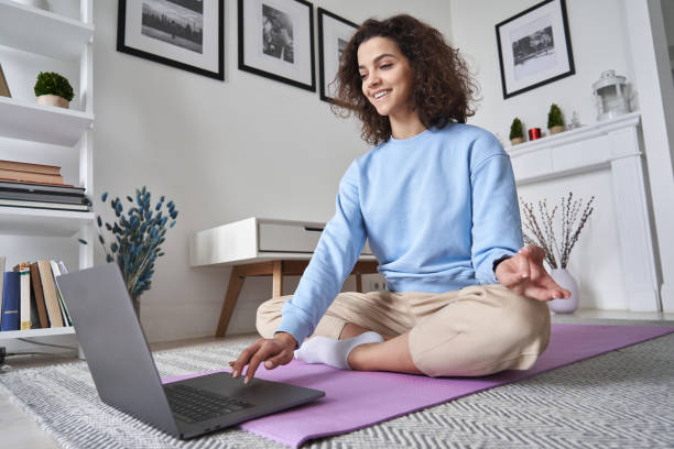 Happy Fit Young Woman Using Laptop Computer Watching Online Yoga Lesson, Fitness Video Class, Learning Virtual Meditation Training Tutorial, Doing Exercise, Feeling No Stress, Peace Of Mind At Home.