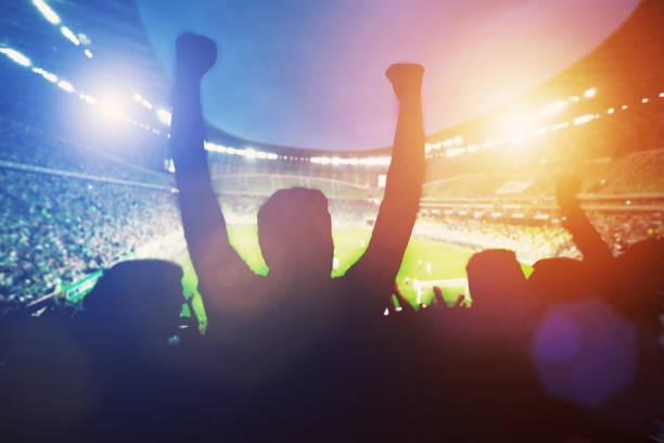 Happy football fans support their team Happy football fans support their team and celebrating goal with hands up. Big stadium fan enthusiast stock pictures, royalty-free photos & images
