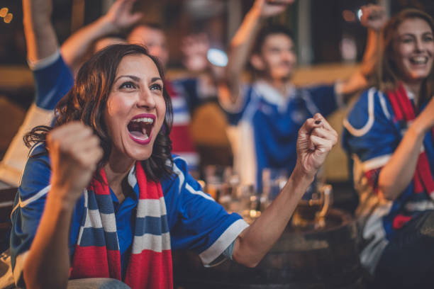Happy for our team Group of friends watching game in a pub, focus on a woman shouting match sport photos stock pictures, royalty-free photos & images