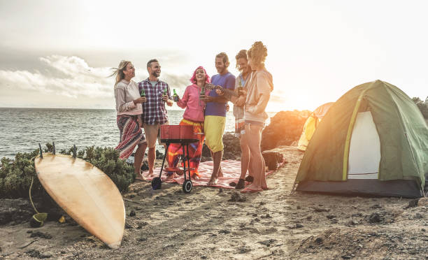 캠핑 바베 큐 피크닉 바다-서퍼 사람들 재미와 함께-메인 웃 고 옆에서 맥주를 마시는 행복 한 친구 권리 들-여행, 휴가 및 우정 개념에 초점 - 대서양 제도 뉴스 사진 이미지