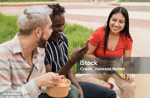 istock Happy friends having fun eating take away food outdoor in the city - Focus on asian girl face 1342449803