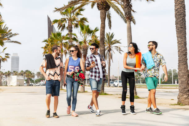 Happy friends on seaside walk in Barcelona - Multiracial group of best friends enjoying summer and time together - Happiness and friendship during a travel in Spain stock photo