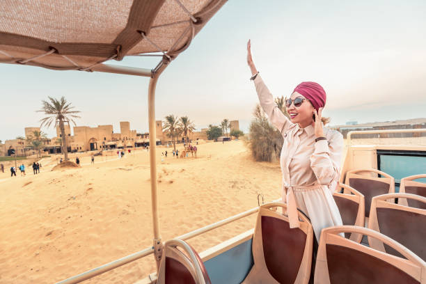 A happy girl in an Indian headdress travels on the roof of a bus in a natural and historical Park. Desert Safari and adventure concept A happy girl in an Indian headdress travels on the roof of a bus in a natural and historical Park. Desert Safari and adventure concept hot arabian women stock pictures, royalty-free photos & images