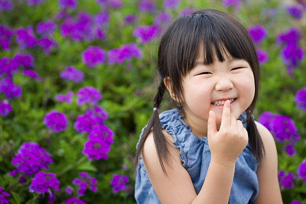 Happy Girl in Flower Garden  chinese girl hairstyle stock pictures, royalty-free photos & images