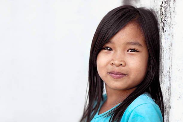 Happy girl outdoors Close up portrait of seven year old girl leaning against a wall and smiling. philippine girl stock pictures, royalty-free photos & images