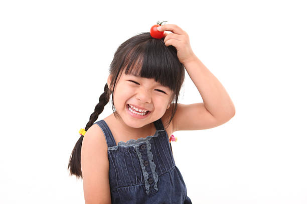 Happy girl playing with fresh cherry tomato Happy girl playing with fresh cherry tomato chinese girl hairstyle stock pictures, royalty-free photos & images