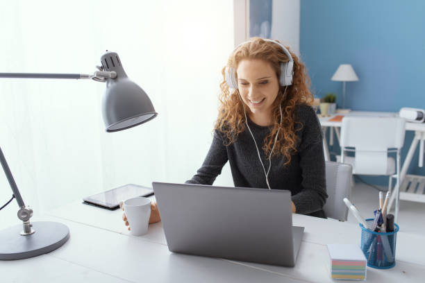 Happy girl watching movies online Happy young student girl wearing headphones and watching movies online, leisure and entertainment concept online education stock pictures, royalty-free photos & images