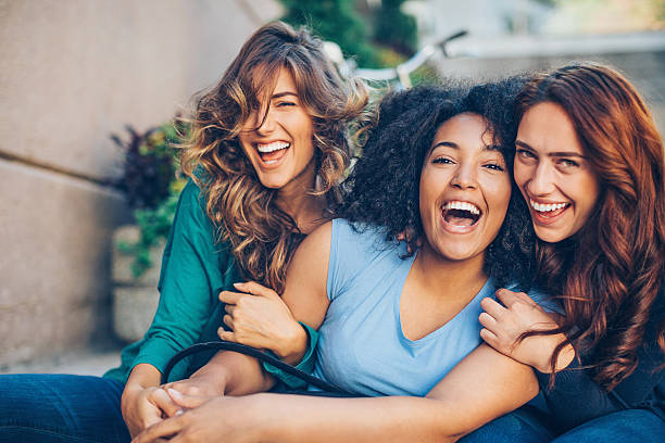 Happy girlfriends Three young women laughing outdoors female friendship stock pictures, royalty-free photos & images