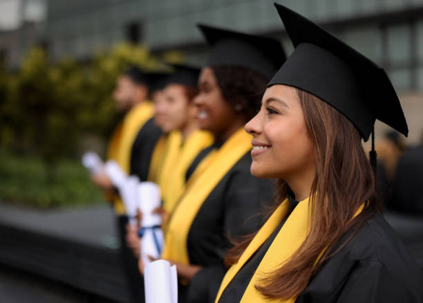 Happy group of graduate students in a row holding their diplomas Happy group of graduate students in a row holding their diplomas on their graduation day and smiling - education concepts universities stock pictures, royalty-free photos & images