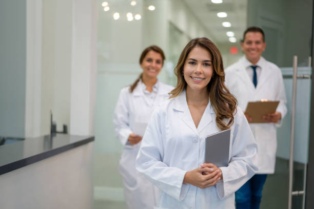 Happy group of Latin doctors working at a clinic Portrait of a happy group of Latin doctors working at a clinic and looking at the camera smiling - healthcare and medicine concepts dental clinic stock pictures, royalty-free photos & images