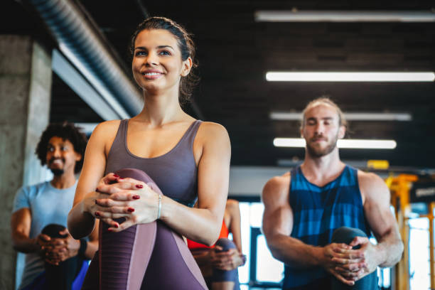 Happy group of people exercising at the gym stock photo