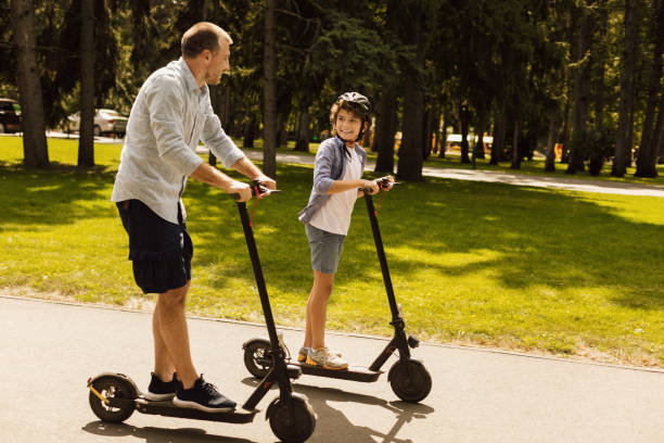 gelukkige kerel met papa die rit op e-scooter heeft - elektrische step stockfoto's en -beelden