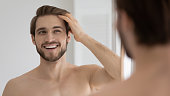 istock Happy handsome young guy combing smooth brown hair with fingers 1327874212
