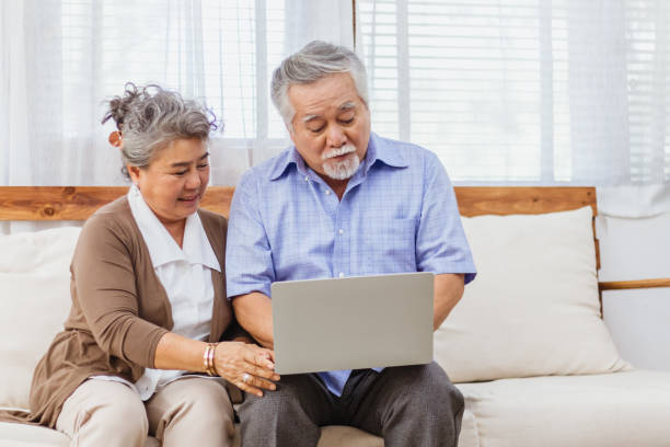 Happy healthy Asian senior elderly couple web chat on computer at home. Retired man and woman enjoy shopping or streaming online via website by using laptop. Elder retirement activity and lifestyle Happy healthy Asian senior elderly couple web chat on computer at home. Retired man and woman enjoy shopping or streaming online via website by using laptop. Elder retirement activity and lifestyle free images for downloads stock pictures, royalty-free photos & images