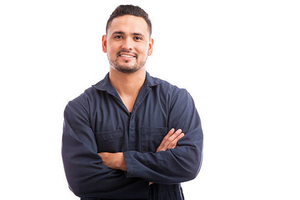 Happy Hispanic mechanic Young Hispanic mechanic wearing overalls and smiling with his arms crossed blue collar worker stock pictures, royalty-free photos & images