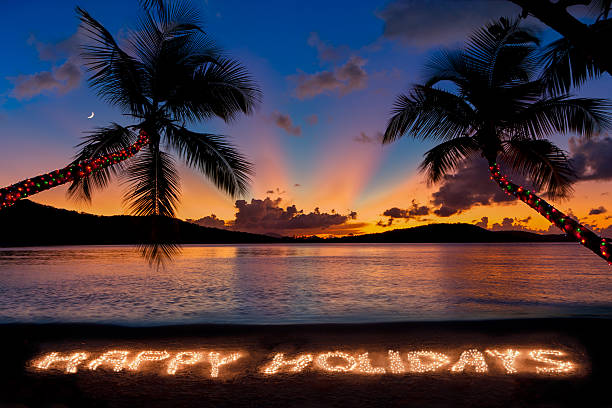 Happy Holidays made with Christmas lights at a tropical beach stock photo