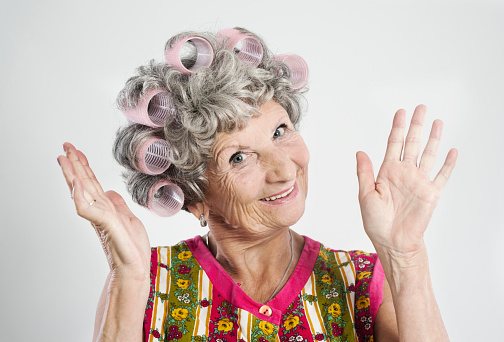 "Stereotypical houswife with curlers, 69 years old, isolated on whiteO...