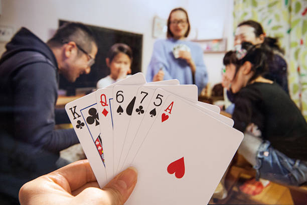 Happy Japanese family and friends playing cards stock photo