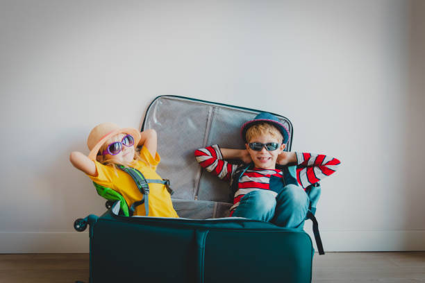 happy kids - jongen en meisje - geniet van verpakking en reizen - packing suitcase stockfoto's en -beelden