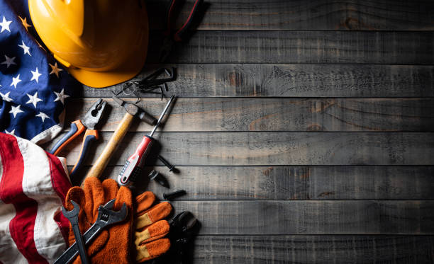 Happy Labor day concept. American flag with different construction tools on dark wooden background, with copy space for text. Happy Labor day concept. American flag with different construction tools on dark wooden background, with copy space for text. labor day stock pictures, royalty-free photos & images