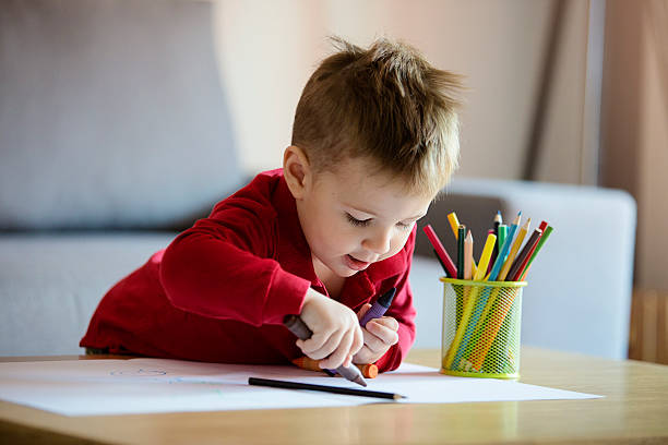 Happy little boy coloring stock photo