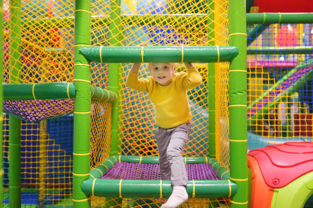 Happy little boy having fun in amusement in play center. Child playing on indoor playground. Happy little boy having fun in amusement in play center. Child playing on indoor playground. Active birthday party for preschooler kids. indoor playground stock pictures, royalty-free photos & images