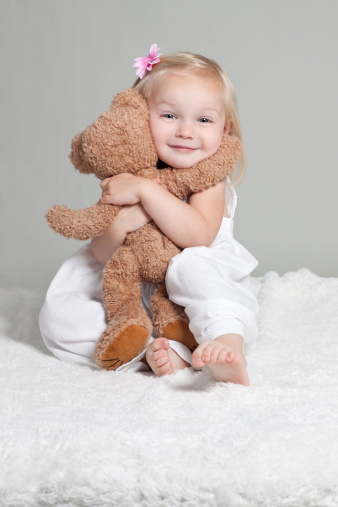 Happy Little Girl In White Dress Hugging Stuffed Animal Stock Photo - Download Image Now - iStock