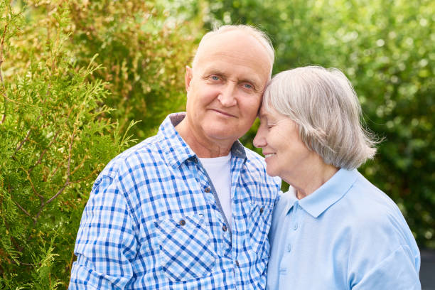Happy  Long Marriage Portrait of loving senior couple embracing tenderly posing for camera in beautiful garden long stock pictures, royalty-free photos & images