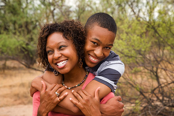 Happy lovely African-American family together Good-looking single-parent mom and son mother and teenage son stock pictures, royalty-free photos & images