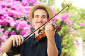 Portrait of a happy man playing violin outside