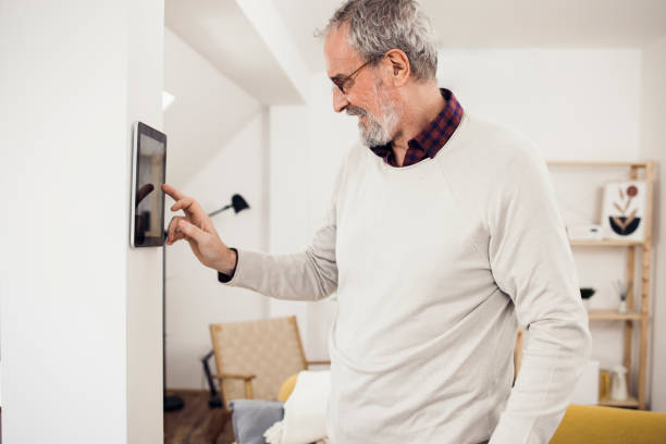 Happy man using a smart system at his house stock photo